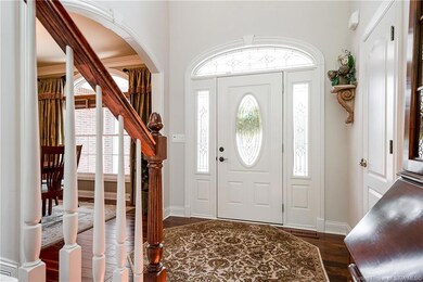 Gorgeous foyer boasts wood flooring and a front do