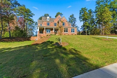 View of front of property with a front yard, covered porch, and brick siding