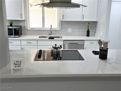 Kitchen with white cabinets, ventilation hood, a s