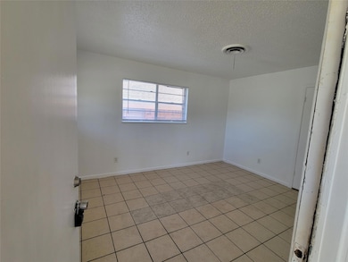 Unfurnished room featuring visible vents, baseboar