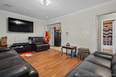 Living room with crown molding and light wood-styl