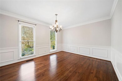 Unfurnished room with ornamental molding, dark woo