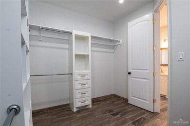 Spacious closet featuring dark wood-style floors