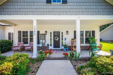 Doorway to property with a porch and mansard roof