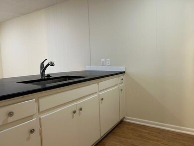 Kitchen with baseboards, a sink, dark countertops