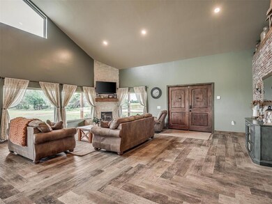 Living area featuring high vaulted ceiling and a stone fireplace