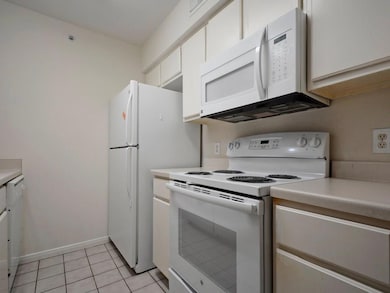 Kitchen with white appliances, light countertops,