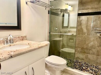 Full bath with a stall shower, toilet, vanity, and