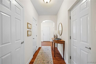 Hall with arched walkways, dark wood-type flooring