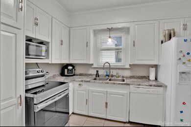 Kitchen featuring ornamental molding, white applia