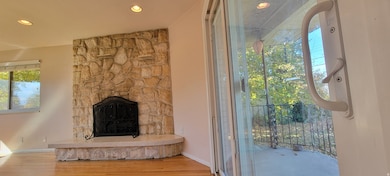 Detailed view of wood finished floors, a fireplace, and recessed lighting