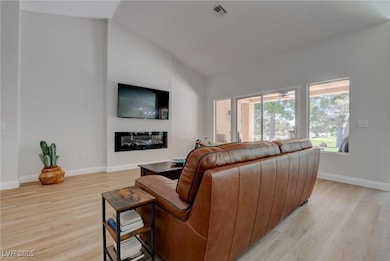 Living room with light wood-type flooring, baseboa