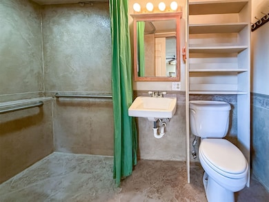 Wheelchair-accessible bathroom featuring a wainscoted wall, and tile patterned floors