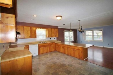 Open kitchen with tons of counter space and updated vinyl flooring.