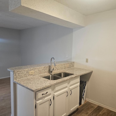 Kitchen with a sink, baseboards, a peninsula, and
