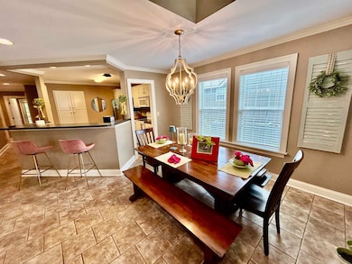 Dining area with crown molding, baseboards, and a chandelier