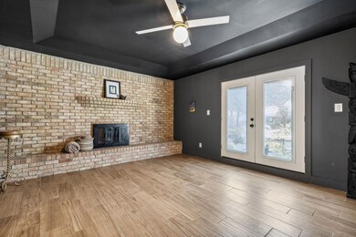 Front living area with fireplace focal wall and french doors to the front yard.