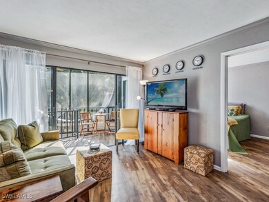 Living room with wood-style floors and crown moldi