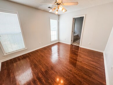 Unfurnished room featuring wood-type flooring, ceiling fan, and a textured ceiling
