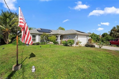 View of front facade with roof mounted solar panels, stucco siding, a front lawn, and an attached garage