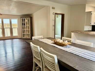 Dining room with a textured ceiling and dark wood-style floors