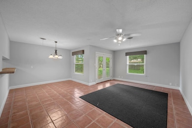 Tiled spare room featuring a textured ceiling, ce