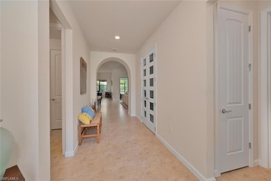 Hall with arched walkways, light tile patterned fl
