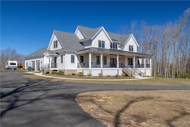 View of front facade with a shingled roof and covered porch