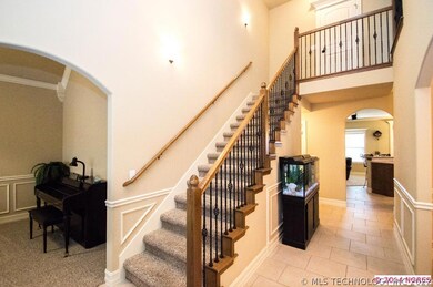 Rich, warm wood and iron spindles staircase leads