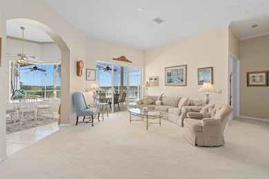 Living Room with a Gorgeous View of the Lanai, Pool, Golf Course and Water. WOW!