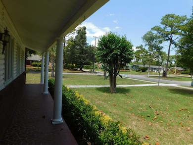 View of grassy yard featuring a porch