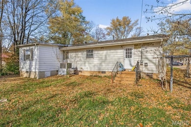 Rear view of property featuring crawl space and a lawn