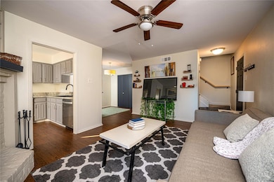 Living room featuring ceiling fan, sink, and dark 