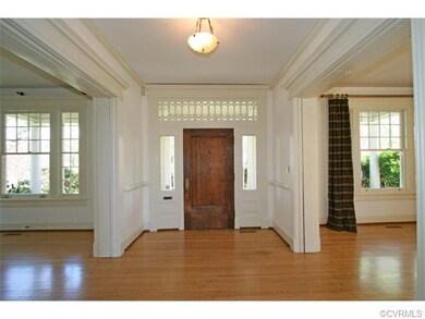 Front door features a decorative glass transom and side lights. The oversize windows fill the rooms with light, and the house sparkles with fresh paint and newly refinished floors.