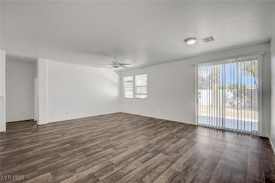 Spare room featuring ceiling fan, dark wood-type f