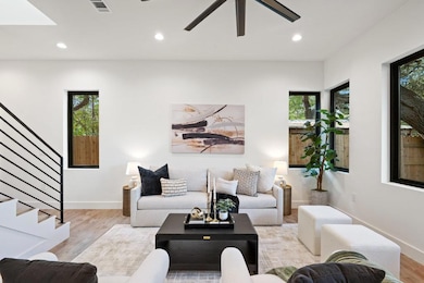 Living area featuring wood finished floors, recessed lighting, stairway, and ceiling fan