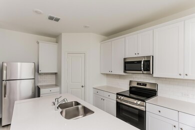 Kitchen with stainless steel appliances and white cabinets