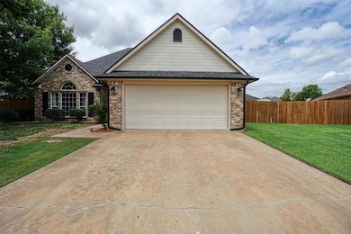 Traditional-style home with concrete driveway, brick siding, a garage, and roof with shingles