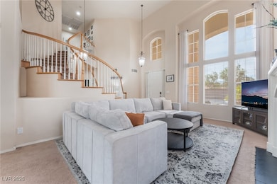 Living area with a high ceiling, carpet, and stair