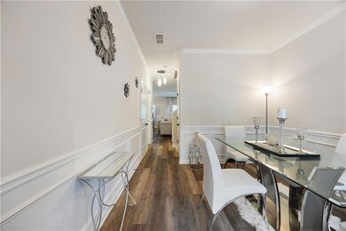Dining area featuring ornamental molding, wainscoting, and wood finished floors
