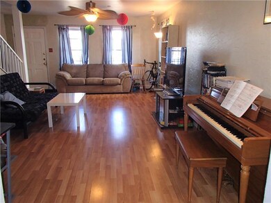 Living room with stairs, wood finished floors, an
