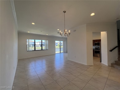 Empty room featuring ornamental molding, light tile patterned flooring, recessed lighting, a chandelier, and stairs