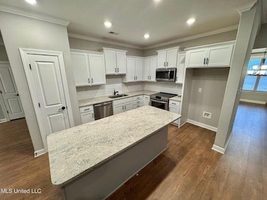 Kitchen featuring white cabinets, stainless steel 