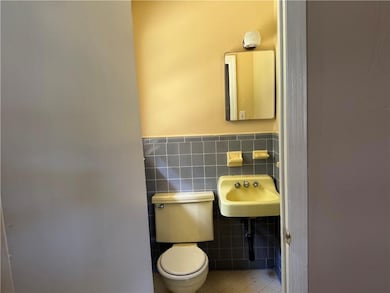 Bathroom featuring tile walls, tile patterned floors, pet washing area, and wainscoting