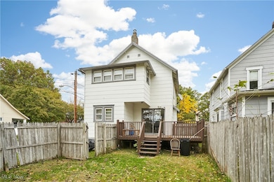 Rear view of house featuring a deck, a fenced backyard.