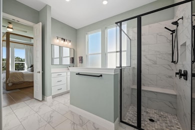 The primary bath delivers modern spa vibes with marble-look tile, dual vanities, and a glass shower.