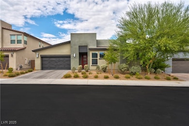 View of front facade featuring stucco siding, decorative driveway, and an attached garage