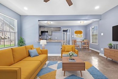 Living room with concrete flooring, ceiling fan, and recessed lighting
