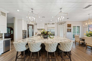 Kitchen featuring glass insert cabinets, pendant lighting, a chandelier, decorative backsplash, and recessed lighting