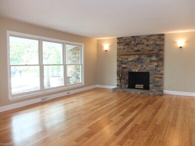 Living room with wood flooring and a stone firepla